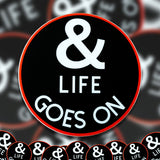 A pile of & Life Goes On stickers. 