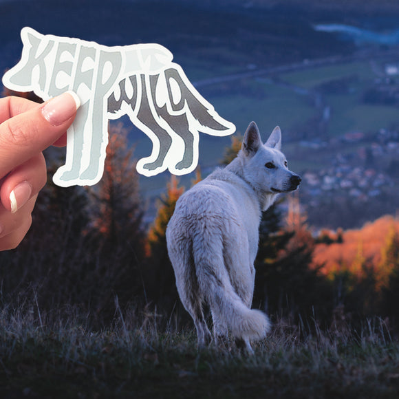 A Keep It Wild sticker behind a wolf. 