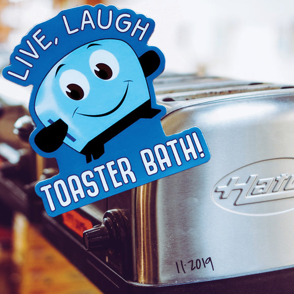 A Live, Laugh Toaster Bath sticker in front of a couple of toasters.