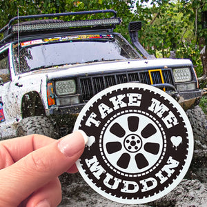 A Take Me Muddin' sticker in front of a 4x4 in the mud. 