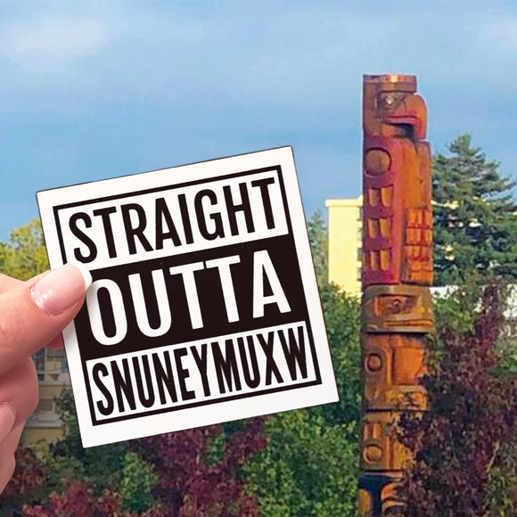 A Straight Outta Snuneymuxw sticker beside a totem in Nanaimo.