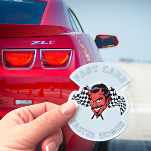 This is a pic of a hand holding a Fast Cars Faster Women sticker in front of a beautiful red Chevy Camaro ZL1.  